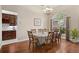 Elegant dining room features hardwood floors, a classic chandelier, and a view of the landscaped exterior at 807 Grovesmere Loop, Ocoee, FL 34761