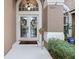 Inviting front entry with double doors, transom window, and lush landscaping at 807 Grovesmere Loop, Ocoee, FL 34761
