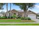 Beautiful single-story home with lush landscaping, mature trees, and inviting curb appeal at 807 Grovesmere Loop, Ocoee, FL 34761