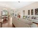 Open living room with hardwood floors, comfortable seating, and a clear view to the dining area at 807 Grovesmere Loop, Ocoee, FL 34761
