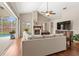 Bright living room showcases a stone fireplace, hardwood floors, and views of the screened-in outdoor pool at 807 Grovesmere Loop, Ocoee, FL 34761