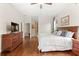 Well-lit main bedroom with hardwood floors, ceiling fan, dresser, and closet at 807 Grovesmere Loop, Ocoee, FL 34761