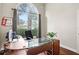 Home office with abundant natural light streaming through a large arched window at 807 Grovesmere Loop, Ocoee, FL 34761