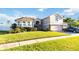 Two story house exterior, landscaping, and driveway with car at 10642 Cloudview Dr, Orlando, FL 32825