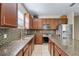 Kitchen features wood cabinetry, stainless steel appliances, tile backsplash, and granite countertops at 12079 Alder Branch Loop, Orlando, FL 32824