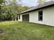 Home's back exterior featuring a covered patio and a large backyard at 347 Mission Rd, Oviedo, FL 32765