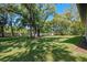 Lush backyard features mature trees, well-kept lawn, and a fence line at 347 Mission Rd, Oviedo, FL 32765