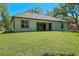 A view of the home's backyard featuring a lush lawn, sliding glass door, and an abundance of natural light at 347 Mission Rd, Oviedo, FL 32765