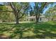 Green backyard with trees and the exterior view of the rear of the home at 347 Mission Rd, Oviedo, FL 32765