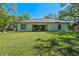 Large backyard featuring lush lawn, mature trees, and a view of the home's rear exterior at 347 Mission Rd, Oviedo, FL 32765