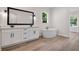 Bright bathroom featuring double sink vanity and modern soaking tub at 347 Mission Rd, Oviedo, FL 32765