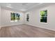 Bright bedroom featuring tray ceiling, recessed lights, multiple windows, and wood-look flooring at 347 Mission Rd, Oviedo, FL 32765