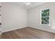 Bright bedroom featuring a ceiling fan, a large window and wood-look flooring at 347 Mission Rd, Oviedo, FL 32765