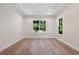 Spacious bedroom featuring tray ceiling, recessed lights, multiple windows, and wood-look flooring at 347 Mission Rd, Oviedo, FL 32765