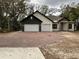 Charming exterior of a two-story home featuring a brick driveway and two-car garage at 347 Mission Rd, Oviedo, FL 32765