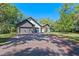 Beautiful exterior view features a long brick driveway, well-maintained lawn, and three car garage at 347 Mission Rd, Oviedo, FL 32765