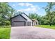 A beautiful home with a brick driveway, three-car garage, green lawn, and mature trees at 347 Mission Rd, Oviedo, FL 32765