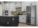 Close-up of the kitchen with stainless steel appliances, custom cabinets, and a center island at 347 Mission Rd, Oviedo, FL 32765