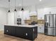 Elegant kitchen island with modern appliances, lighting and white cabinets at 347 Mission Rd, Oviedo, FL 32765