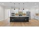 Bright kitchen with large island, modern pendant lighting, and stainless steel appliances at 347 Mission Rd, Oviedo, FL 32765