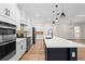 Modern kitchen boasts white cabinetry, stainless steel appliances, and a center island at 347 Mission Rd, Oviedo, FL 32765