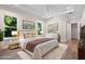 A well-lit bedroom features tray ceiling, hardwood floors, and a cozy rug, with art to create a serene ambiance at 347 Mission Rd, Oviedo, FL 32765