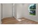 Neutral room with wood flooring, window, white trim, and frosted glass door to hallway at 347 Mission Rd, Oviedo, FL 32765