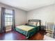 Spacious bedroom with a king-size bed, wood floors, and large window at 4408 Sun Village Blvd, Kissimmee, FL 34746