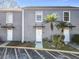 Front view of two-story townhouses with gray exterior and palm trees at 4408 Sun Village Blvd, Kissimmee, FL 34746