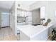 Small galley kitchen features white cabinets, stainless steel appliances, and a breakfast bar at 4408 Sun Village Blvd, Kissimmee, FL 34746