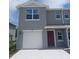 Charming two-story home featuring a one-car garage and a vibrant red front door at 547 Zinfandel Dr, Holly Hill, FL 32117