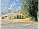 Single-story home with attached garage, landscaping, and a gravel driveway at 8490 Se 110Th Street Rd, Belleview, FL 34420