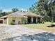 Single-story home with attached garage, landscaping, and a gravel driveway at 8490 Se 110Th Street Rd, Belleview, FL 34420