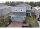 Two-story house with gray siding, two-car garage, and a paved driveway at 1547 Scrub Jay Ct, Deland, FL 32724