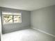 Minimalist bedroom with modern flooring, neutral paint, and a window with outdoor views at 5789 Windhover Dr # E03, Orlando, FL 32819