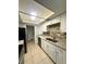Well-equipped kitchen with updated countertops, stainless steel appliances, and convenient access to the laundry area at 5789 Windhover Dr # E03, Orlando, FL 32819