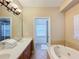 Bathroom with double sinks, a soaking tub, and glass shower stall at 7405 Excitement Dr, Kissimmee, FL 34747