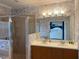 Stylish bathroom featuring a double sink vanity, shower, and wallpaper with eye-catching floral patterns at 7405 Excitement Dr, Kissimmee, FL 34747