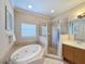 Elegant bathroom with a soaking tub, a glass-enclosed shower, and neutral tile, offering a spa-like experience at 7405 Excitement Dr, Kissimmee, FL 34747