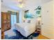 Bright bedroom featuring a queen-size bed, ceiling fan, wood floors, and a vibrant mural on the wall at 7405 Excitement Dr, Kissimmee, FL 34747