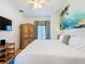 Bright bedroom featuring a queen-size bed, ceiling fan, wood floors, and a vibrant mural on the wall at 7405 Excitement Dr, Kissimmee, FL 34747