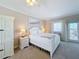 Bright bedroom featuring a white bed, ceiling fan, and a large mirror at 7405 Excitement Dr, Kissimmee, FL 34747