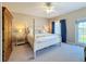 Bedroom with a four-poster bed, carpet, a wood armoire and side tables with lamps at 7405 Excitement Dr, Kissimmee, FL 34747