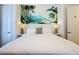 Comfortable bedroom featuring a king-sized bed and a painting of mountains and palm trees at 7405 Excitement Dr, Kissimmee, FL 34747