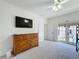 Light-filled bedroom showcasing a dresser, TV, and outdoor balcony access at 7405 Excitement Dr, Kissimmee, FL 34747