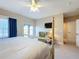 Bedroom with a four-poster bed, french doors to a balcony, lounge chair, and mounted TV at 7405 Excitement Dr, Kissimmee, FL 34747
