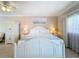 Cozy bedroom boasting a white bed, ceiling fan, and a large window at 7405 Excitement Dr, Kissimmee, FL 34747