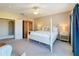 Bedroom features a four-poster bed, wood armoire, and neutral carpet at 7405 Excitement Dr, Kissimmee, FL 34747