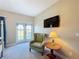 Bedroom features a lounge chair, side table, and french doors that lead to a balcony at 7405 Excitement Dr, Kissimmee, FL 34747