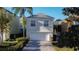 Traditional two-story home featuring a two-car garage and well-maintained landscaping at 7405 Excitement Dr, Kissimmee, FL 34747